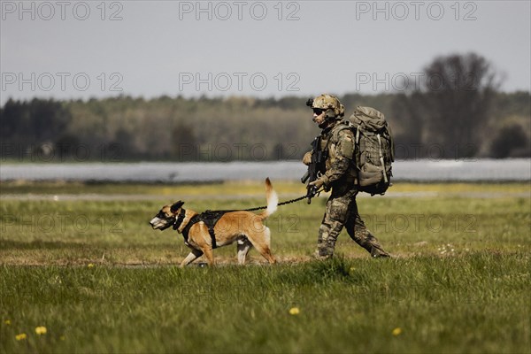 A soldier of the German Armed Forces with a mission dog