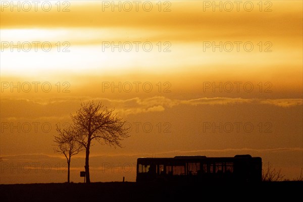 A public bus stands out in the dusk near Gebelzig