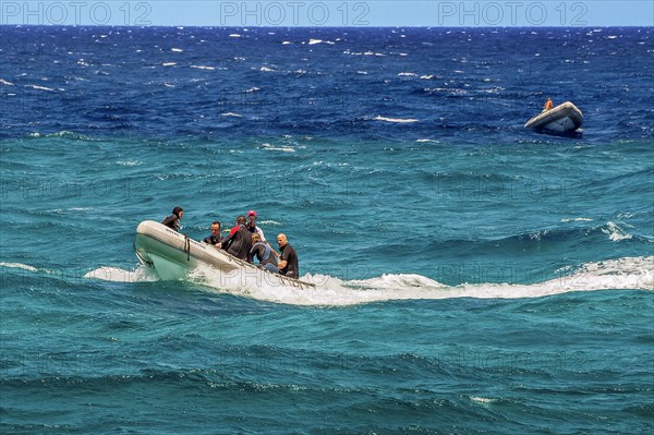 Rubber dinghies with divers in turquoise and blue water on Sanganeb Reef