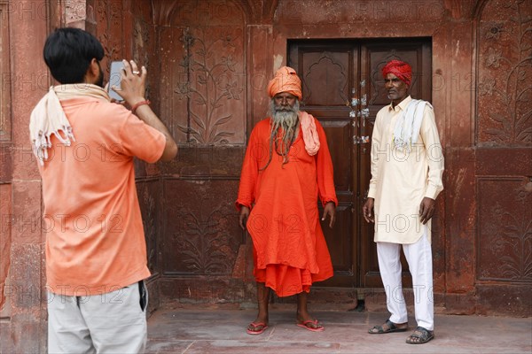 Young man taking a photo of two old Indian men in the Diwan i Am