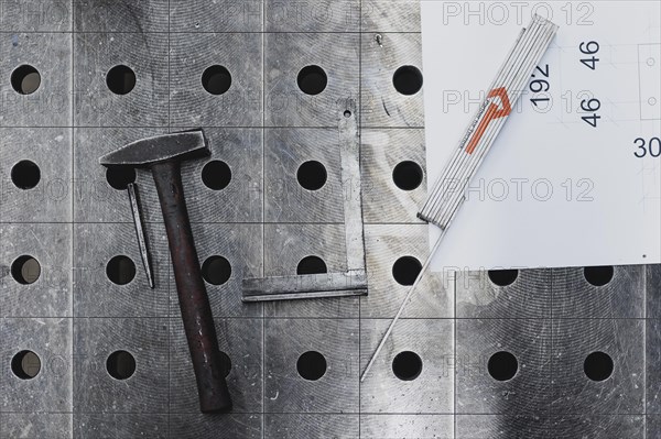 Tools and a technical drawing lying on a workbench