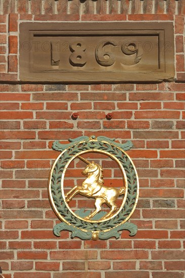 Golden unicorn as town coat of arms with the year 1869 on the Schranne town hall