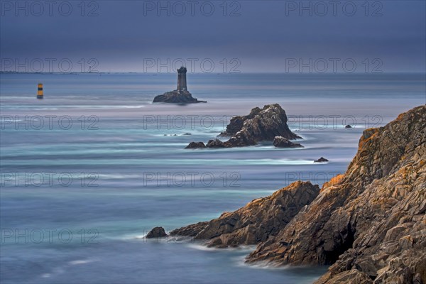 The lighthouse La Vieille in the strait Raz de Sein at dusk at the Pointe du Raz