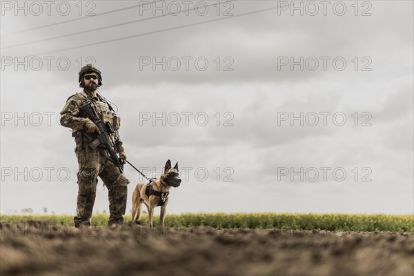 A soldier of the German Armed Forces with a mission dog