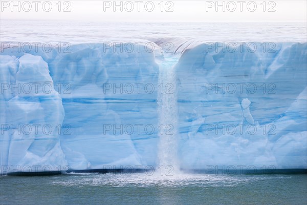 Waterfall at edge of the Brasvellbreen glacier from the ice cap Austfonna debouching into the Barents Sea