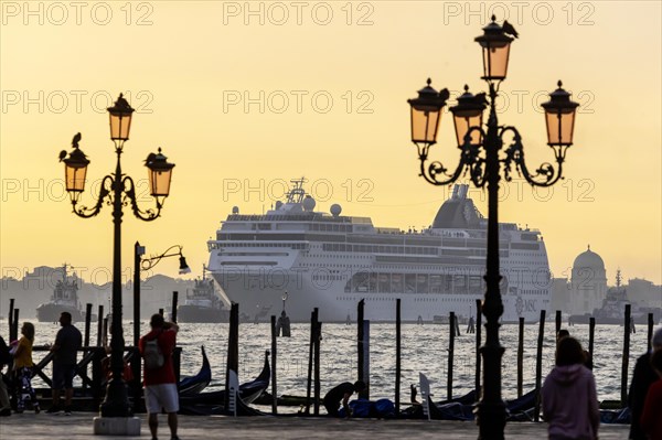 A cruise ship sails to the Stazione Marittima cruise terminal in the early morning. Meanwhile