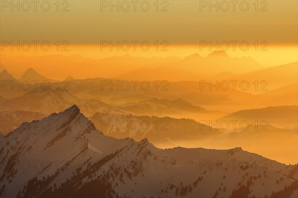 Golden sunset in winter with view from Saentis to Pilatus in Central Switzerland