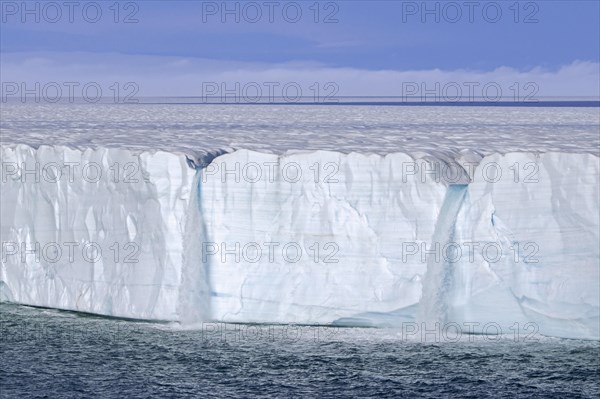 Waterfalls at edge of the Brasvellbreen glacier from the ice cap Austfonna debouching into the Barents Sea