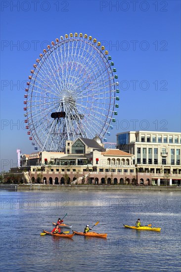 Group of kayaks on excursion and Ferris Wheel Cosmo Clock 21 of Yokohama Cosmo World in background Yokohama city Kanagawa Japan
