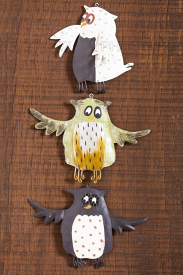 Three owl signs on a wooden surface