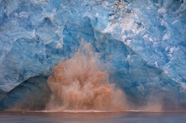 Huge ice chunk breaking from the edge of the Kongsbreen glacier calving into Kongsfjorden