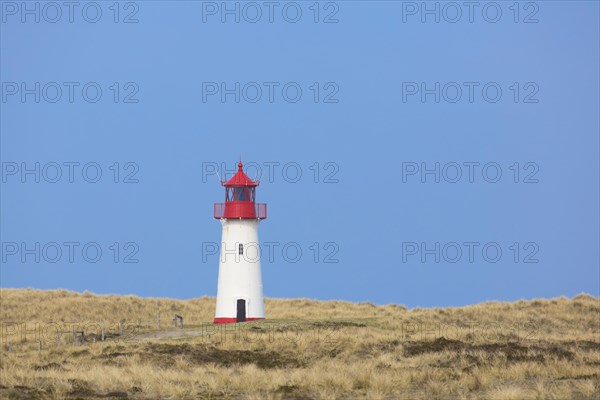 Red and white List-West lighthouse in the dunes on the island Sylt