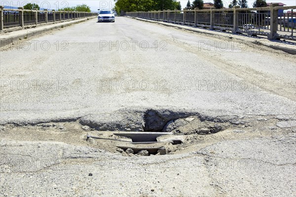 Bumpy road with pothole