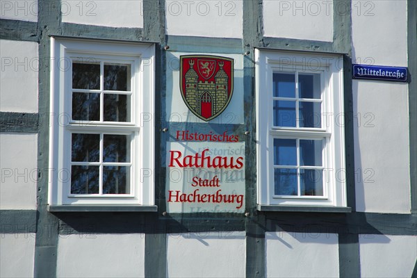 Historic town hall with two windows and town coat of arms