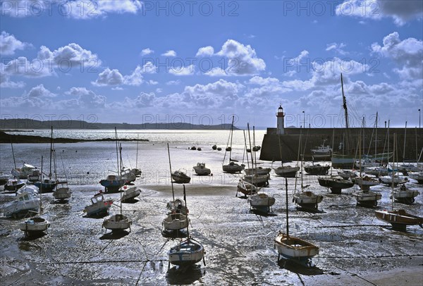 Sailing boats in the harbour of Erquy at sunset at low tide