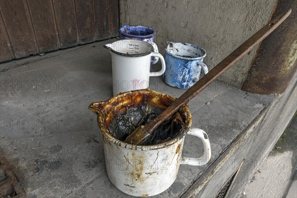 Pot with grease and brush in a former paper factory