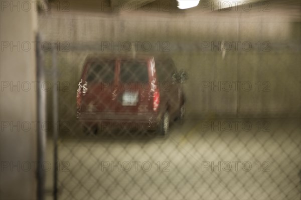 Automobile behind a fence in a parking lot