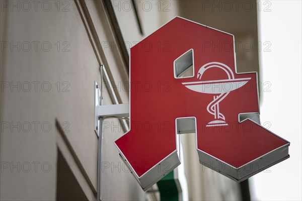 A sign of a pharmacy hangs on a wall of a house in Berlin