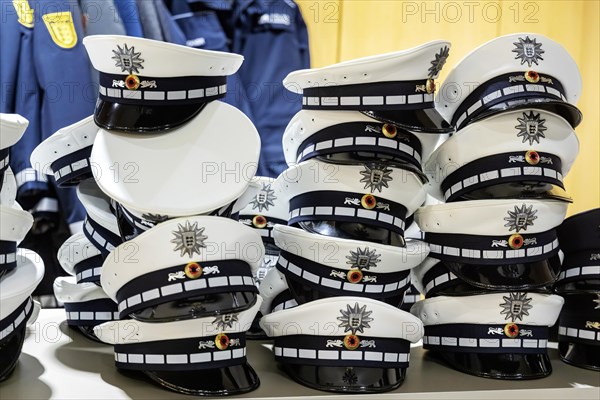 Police caps pile up at a coat rack