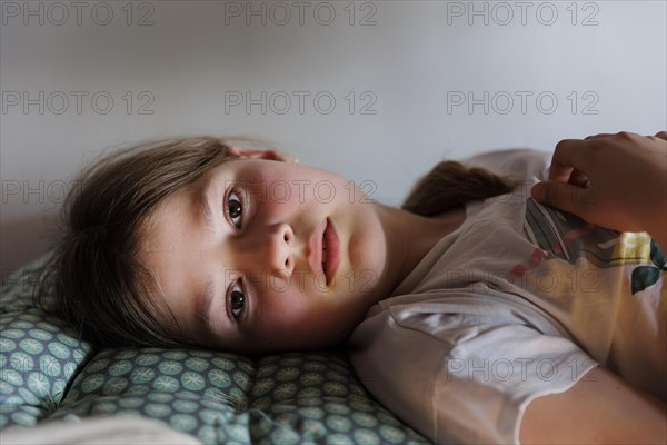 Child lying on the bed daydreaming