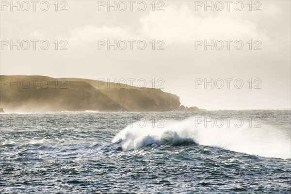 Atmospheric coastal landscape with Summer Isles at sunrise with stormy waves on open sea
