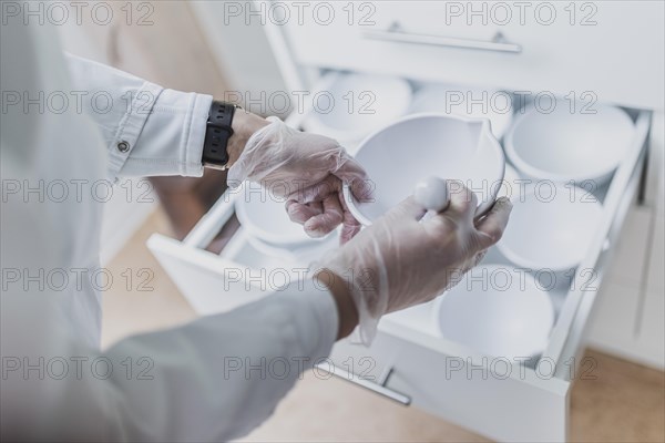 An employee of a pharmacy uses a fantaship with pestle in the prescription