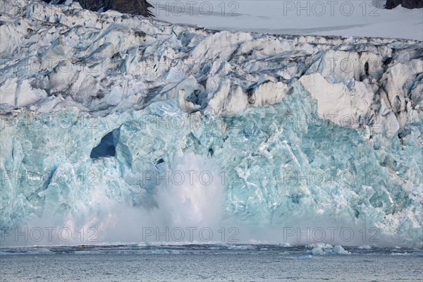 Large chunk of ice breaking off glacier and tumbling in the Magdalenefjord on Svalbard