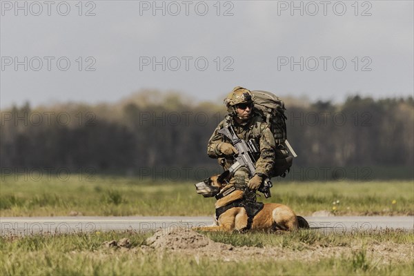 A soldier of the German Armed Forces with a mission dog