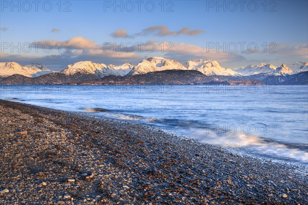 Evening atmosphere at Homer Spit with view over the stone beach and Kachemak Bay to the Kenai Mountains in the warm evening light in the background