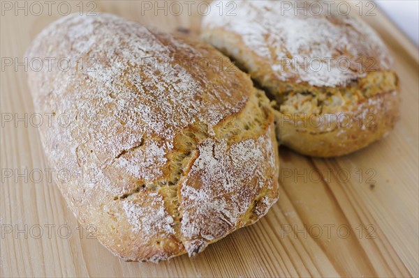 Symbolic photo on the subject of wheat bread. Freshly baked wheat bread lies on a board. Berlin