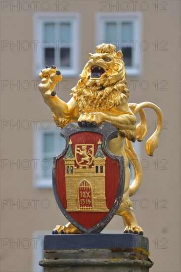 Golden lion figure with town coat of arms and shield at the historic market fountain