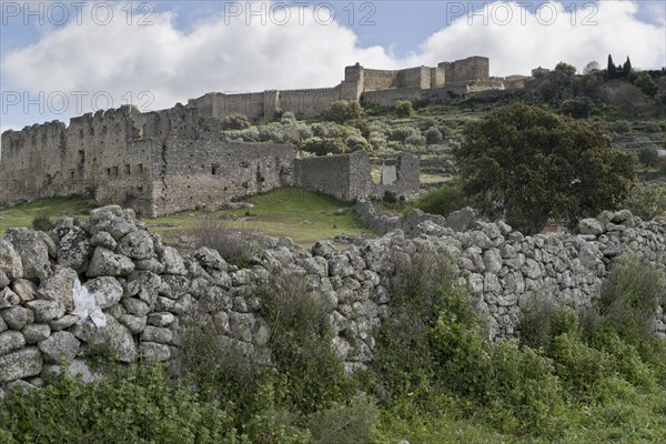 Dry stone wall in front of castle ruins