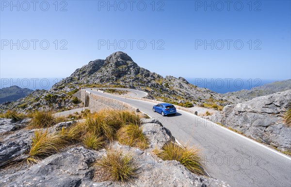 Car at the mountain pass with switchbacks to Sa Colobra