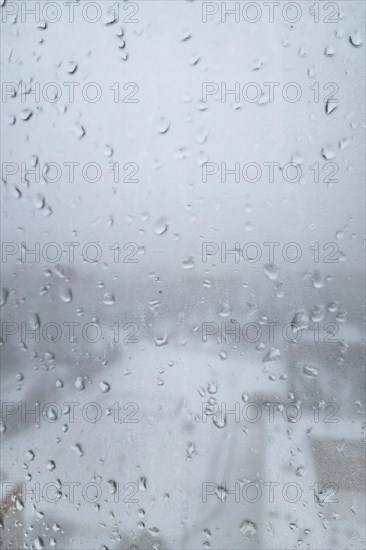 Wet window with rain drops in a foggy day