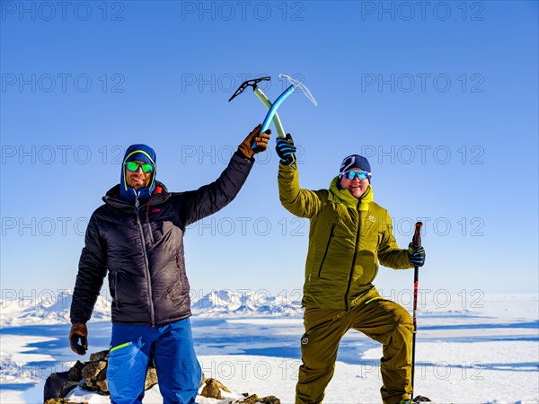 Climbers crossing their picks on the summit of the local mountain