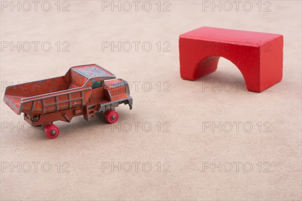 Toy car truck near a brick on a wooden background
