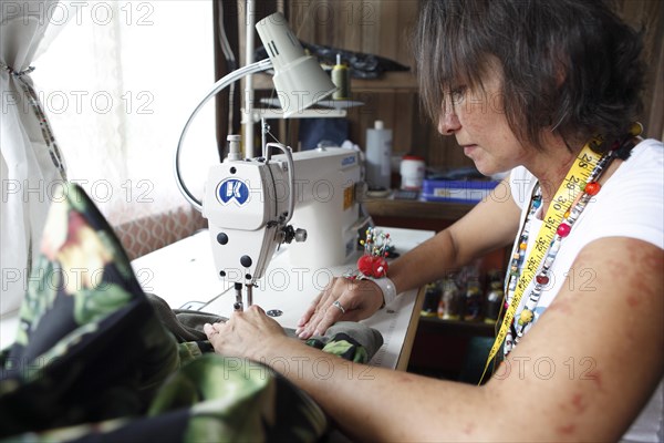 Costa Rican woman sews a bag from recycled fabric