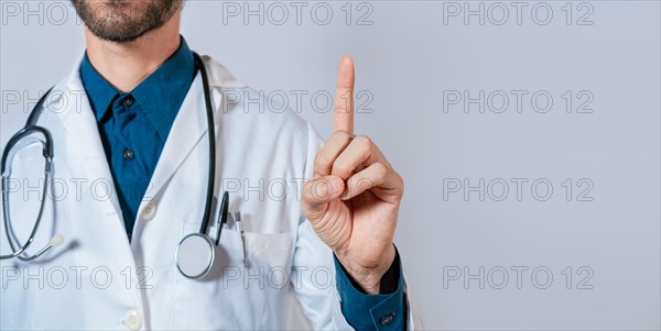 Doctor finger pointing up with text space. Unrecognizable doctor pointing up