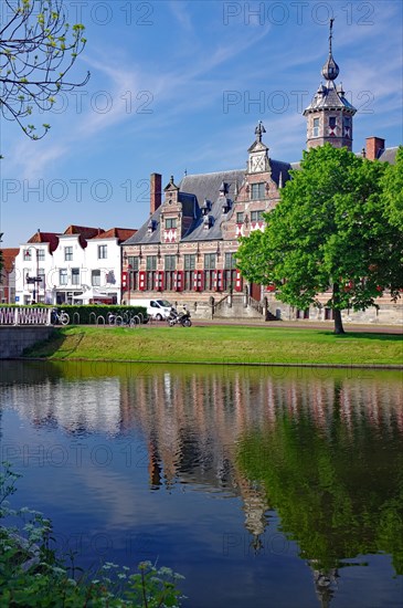 The former town hall reflected in the water of a canal