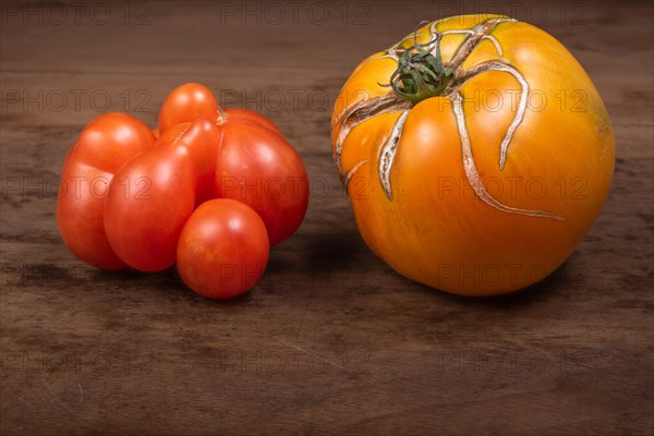 Antique-type tomatoes placed on wooden kitchen table. France