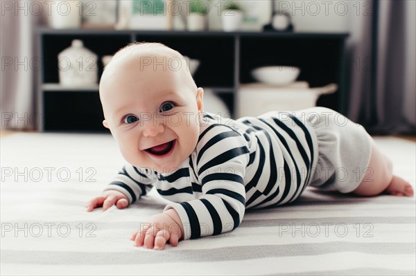 A laughing baby in a striped romper suit