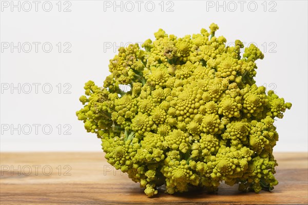 Romanescu cauliflower isolated on a white background on a wooden table