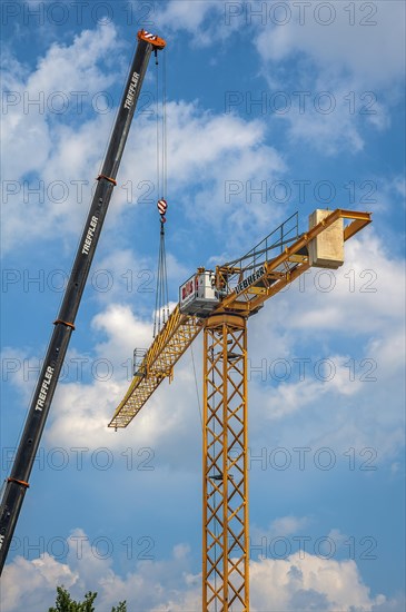 A construction crane is erected with a truck-mounted crane