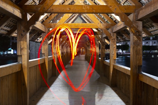 One Person Making a Heartshape with Light Painting on Chapel Bridge