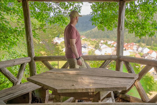 Man standing in wooden pavilion on the hiking trail Sprollenhaeuser Hut