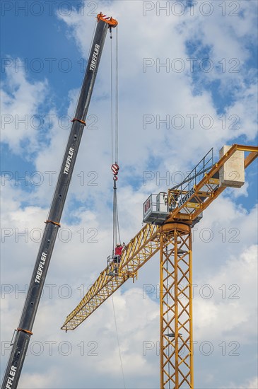 A construction crane is erected with a truck-mounted crane