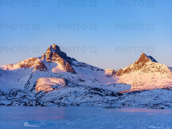 Snowy mountains above the frozen Kong Oscar Fjord
