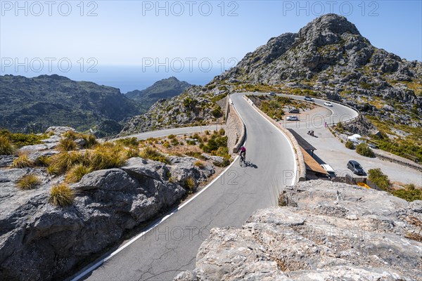 Road cyclists at the mountain pass with serpentines to Sa Colobra