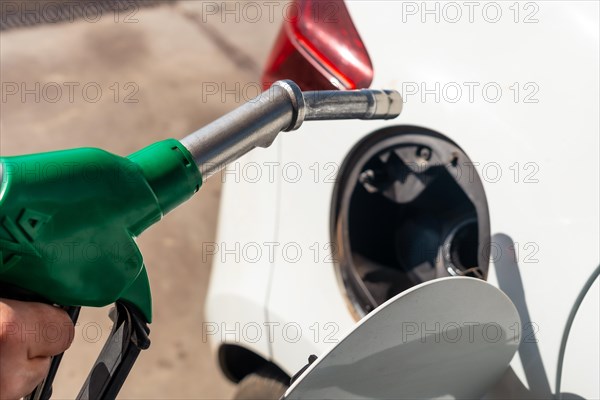 Close-up of a hand with the gun refueling gasoline or diesel fuel in a white car. Concept of transportation