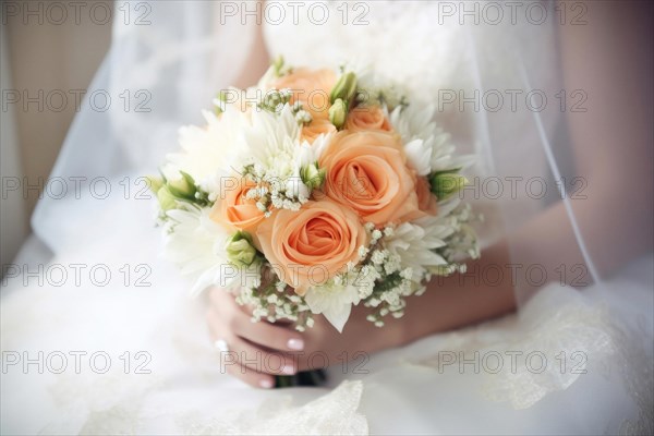 A bride in a white wedding dress holds a beautiful bridal bouquet